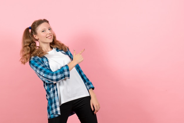 Mulher jovem de camisa quadriculada, vista frontal, posando em fundo rosa modelo mulher emoção criança jovem cor