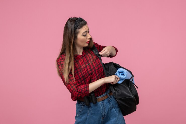 Foto grátis mulher jovem de camisa vermelha com bolsa no modelo de foto de mulher com fundo rosa