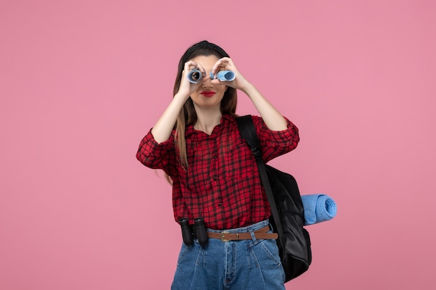 Mulher jovem de camisa vermelha com mapa na cor rosa da moda feminina na mesa de frente