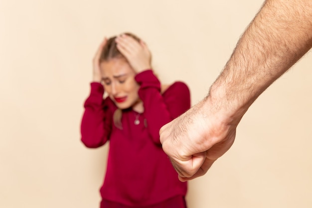 Foto grátis mulher jovem de camisa vermelha de frente para baixo sofre violência física na foto de tecido feminino de espaço creme