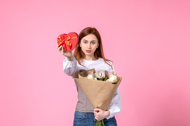 Mulher jovem de frente com flores e presente como presente de dia das mulheres em fundo rosa rosa março feminino data amor mulher sensual igualdade horizontal