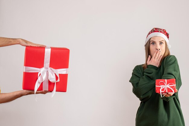 Mulher jovem de frente com um presentinho e aceitando o presente de um homem