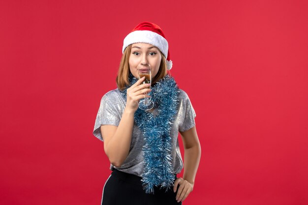 Mulher jovem, de frente, comemorando o ano novo no piso vermelho, feriado de Natal