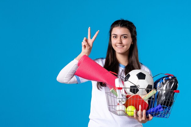 Mulher jovem de frente depois de fazer compras esportivas na parede azul