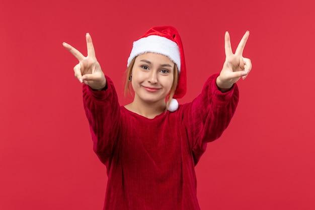 Mulher jovem de frente mostrando número, vermelho feriado natal