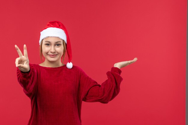 Mulher jovem de frente mostrando número, vermelho feriado natal