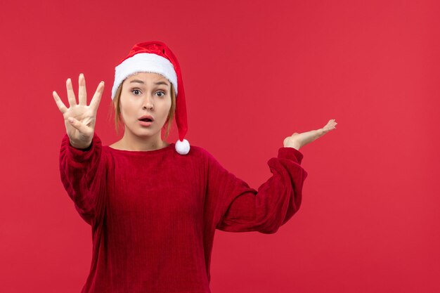 Mulher jovem de frente mostrando número, vermelho feriado natal