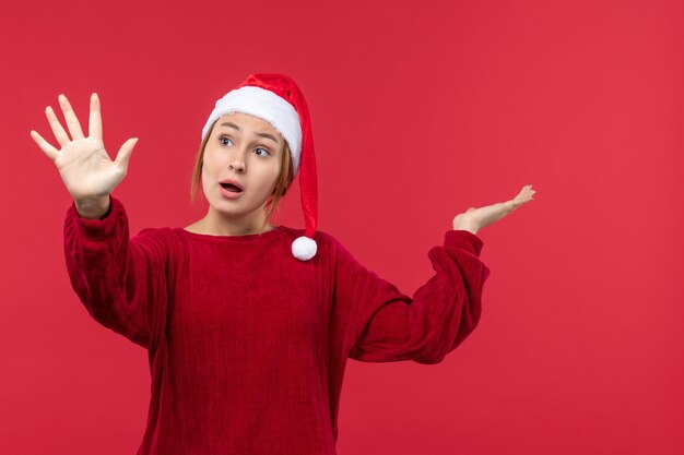 Mulher jovem de frente mostrando número, vermelho feriado natal