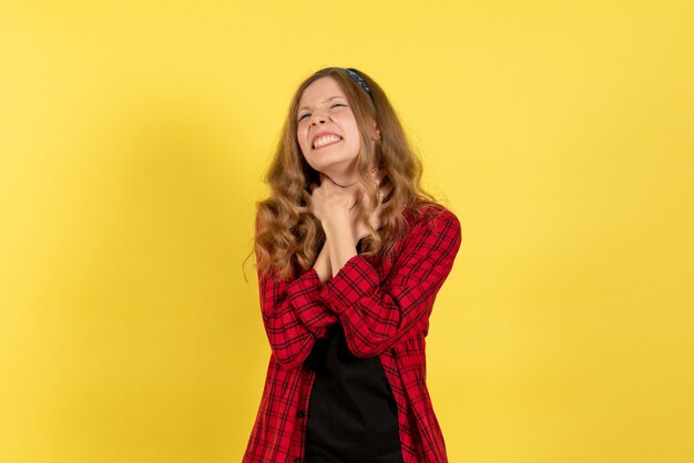 Mulher jovem de frente para a camisa quadriculada vermelha, parada no fundo amarelo meninas cor humana modelo mulher