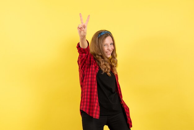 Mulher jovem de frente para a camisa quadriculada vermelha posando com um sorriso no fundo amarelo garota humana emoção cor modelo mulher