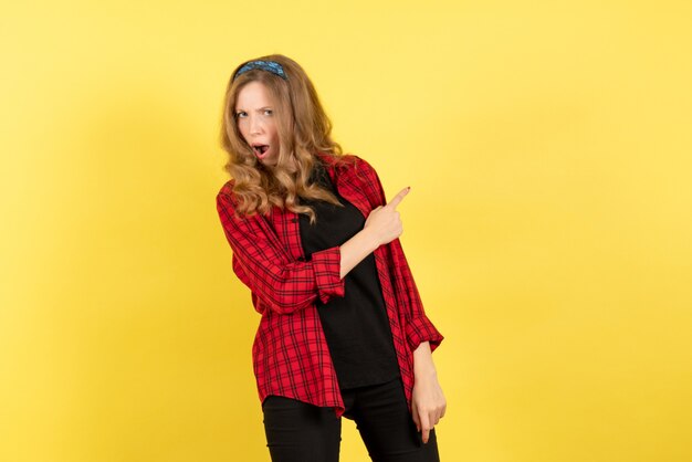 Mulher jovem de frente para a camisa quadriculada vermelha posando em fundo amarelo mulher emoção humana modelo moda garota