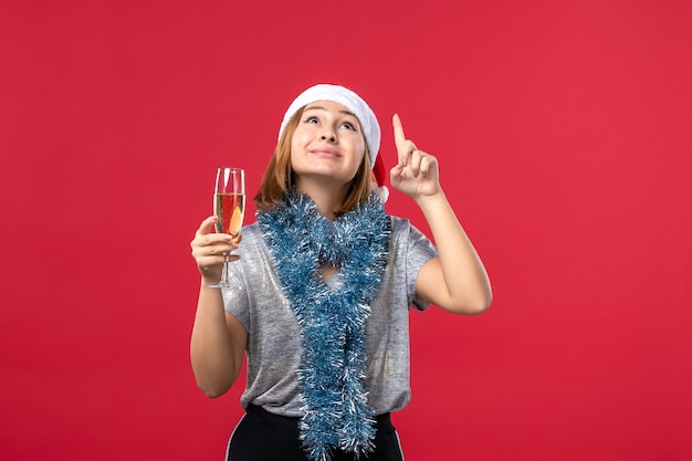 Foto grátis mulher jovem de frente para comemorar o ano novo na parede vermelha feriado cor natal