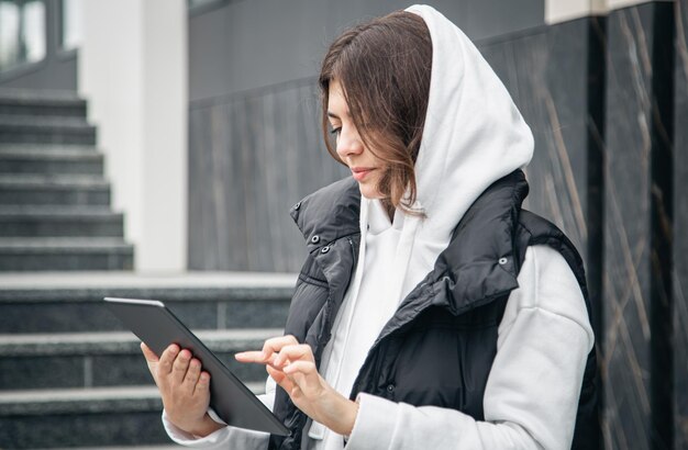 Mulher jovem de negócios com um tablet no fundo do edifício