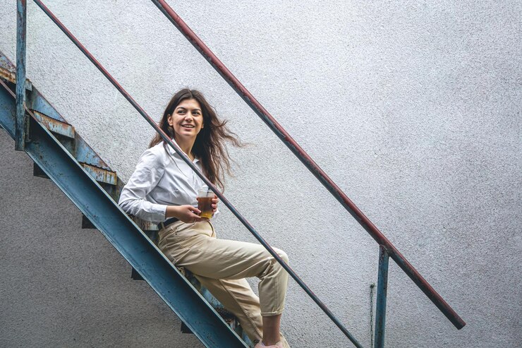 Foto grátis mulher jovem de negócios perto das escadas com uma xícara de café