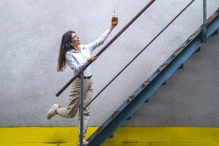 Foto grátis mulher jovem de negócios perto das escadas com uma xícara de café