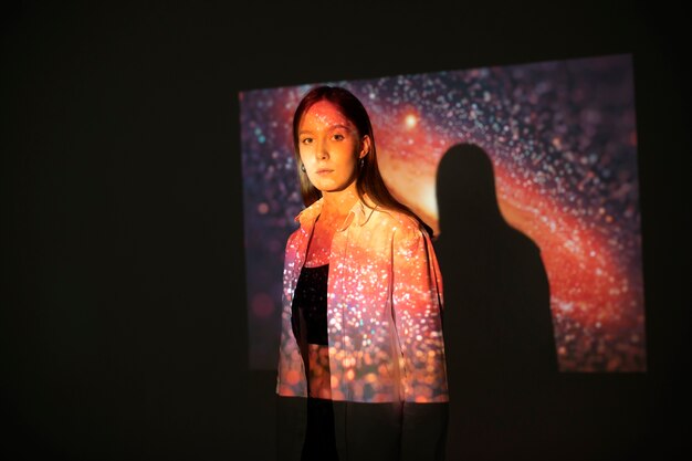 Mulher jovem de pé na projeção da textura do universo