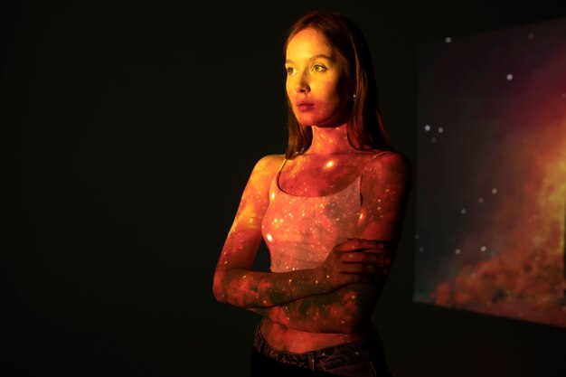 Mulher jovem de pé na projeção da textura do universo