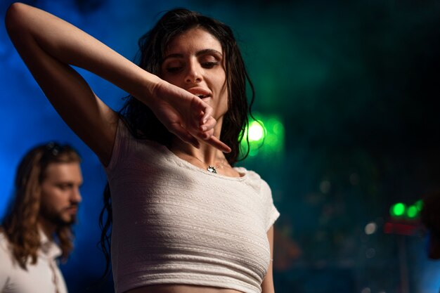 Mulher jovem de tom médio a dançar numa festa de techno.