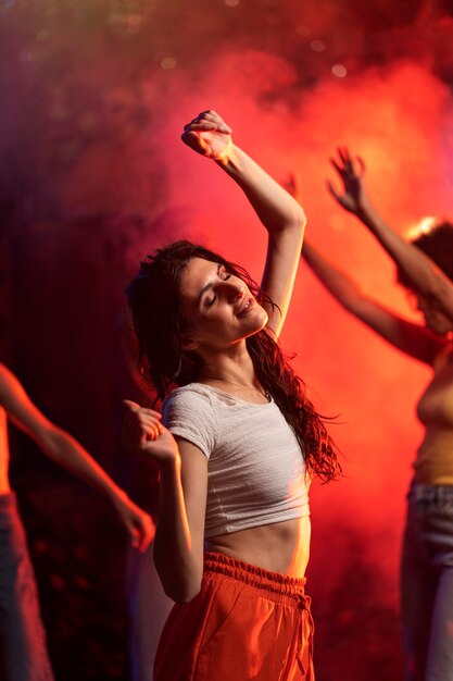 Mulher jovem de tom médio a dançar numa festa de techno.