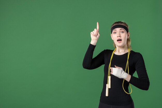 Mulher jovem de vista frontal com bandagem em volta do braço ferido no fundo verde atleta dor, saúde, hospital, mulher, esporte, corpo, treino