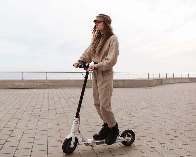 Foto grátis mulher jovem dirigindo uma scooter elétrica