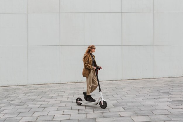 Mulher jovem dirigindo uma scooter elétrica