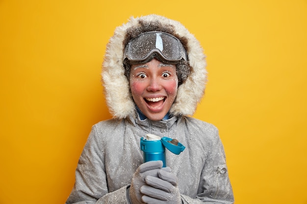 Mulher jovem e alegre, jovem e ativa, gosta de praticar snowboard no inverno, usa jaqueta quente e luvas cobertas com gelo.