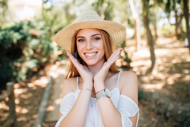 Mulher jovem e atraente, aproveitando seu tempo fora no parque com o pôr do sol no fundo.