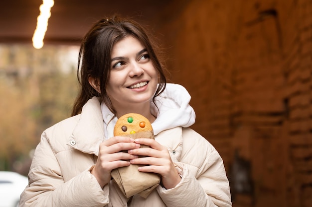 Foto grátis mulher jovem e atraente com pão de gengibre em um espaço de cópia de fundo desfocado
