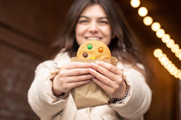 Foto grátis mulher jovem e atraente com pão de gengibre em um fundo desfocado com bokeh