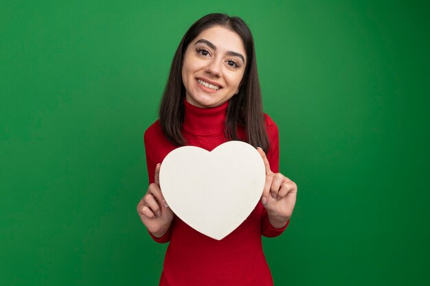 Mulher jovem e bonita caucasiana sorridente segurando um formato de coração