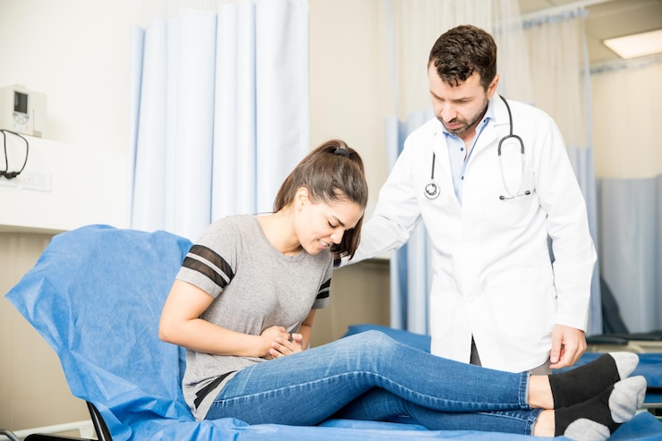 Foto grátis mulher jovem e bonita com dor de estômago severa visitando médico para tratamento