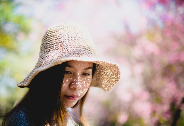 Mulher jovem e bonita com flores de cerejeira desabrochando flores de sakura.