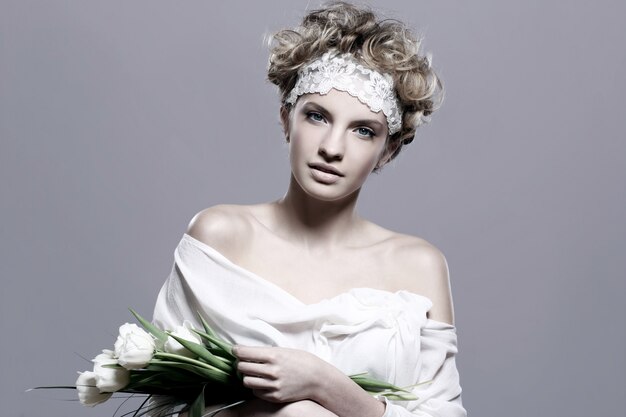 Mulher jovem e bonita com tulipas brancas