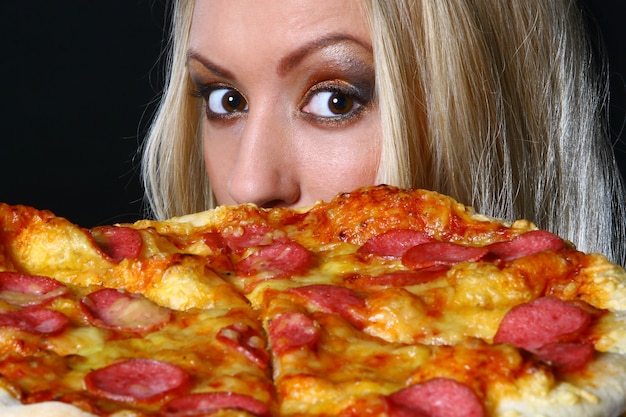 Mulher jovem e bonita comendo pizza