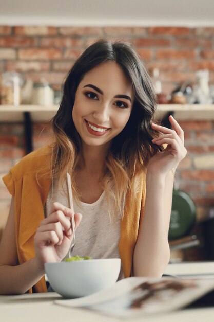 Mulher jovem e bonita comendo uma salada saudável