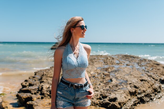 Mulher jovem e bonita de chapéu na praia