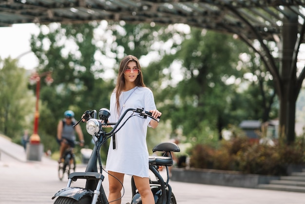 Foto grátis mulher jovem e bonita e uma scooter elétrica