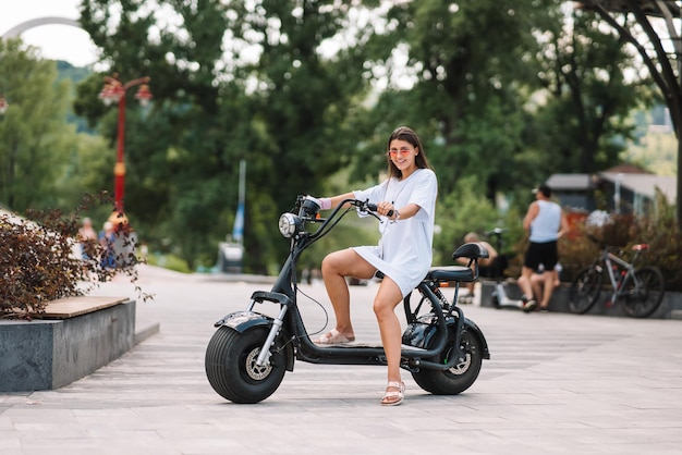 Foto grátis mulher jovem e bonita e uma scooter elétrica