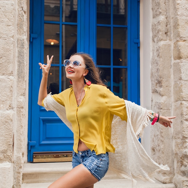 Mulher jovem e bonita elegante caminhando em uma rua da cidade velha