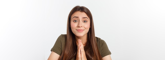 Mulher jovem e bonita em roupas casuais juntos de mãos dadas e rezando isolado no branco