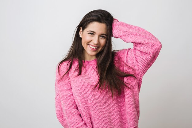 Mulher jovem e bonita em suéter rosa quente, aparência natural, sorrindo, retrato ligado, isolado, cabelo comprido, feliz