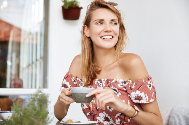 Mulher jovem e bonita em um vestido de café