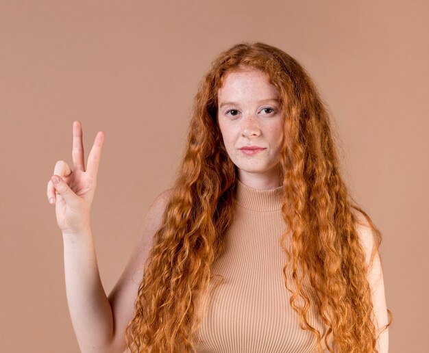 Mulher jovem e bonita ensinando linguagem de sinais