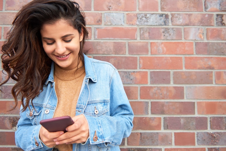 Foto grátis mulher jovem e bonita enviando uma mensagem de texto