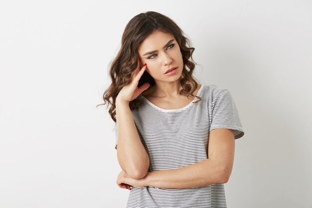 Mulher jovem e bonita, estressada, pensando no problema, estilo hipster, vestida com uma camiseta, isolado no fundo branco,