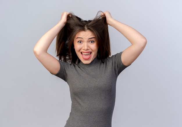 Foto grátis mulher jovem e bonita estressada puxando o cabelo dela, isolado no fundo branco