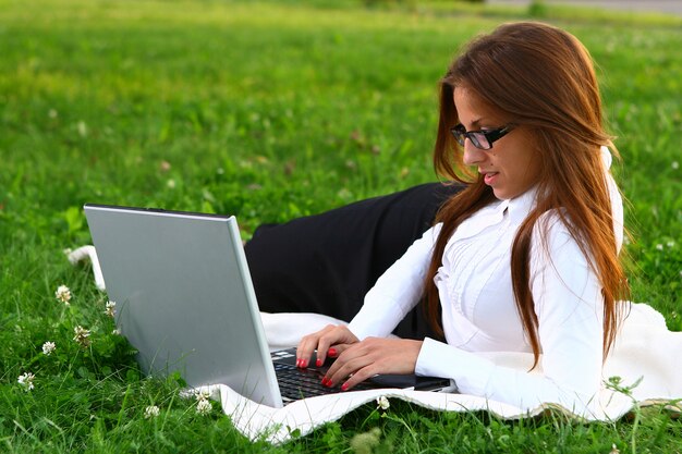 Mulher jovem e bonita estudando no parque