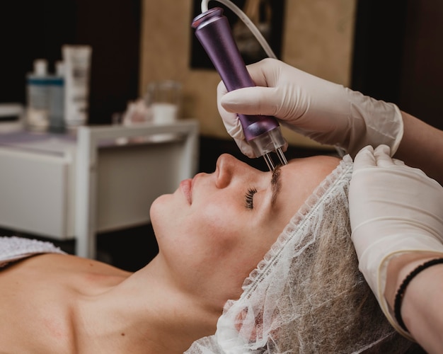 Mulher jovem e bonita fazendo um tratamento cosmético no centro de bem-estar