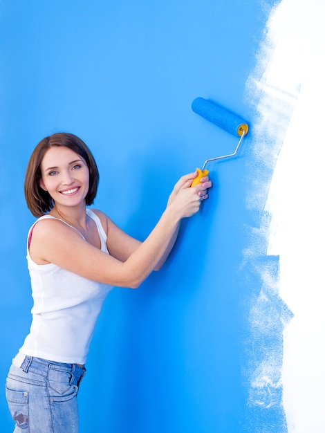 Foto grátis mulher jovem e bonita feliz escovando a parede